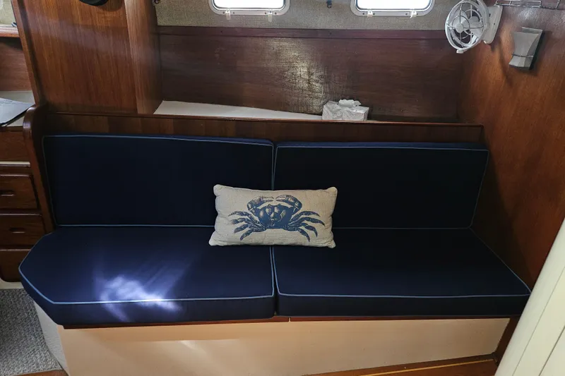 Slide: The Image of Interior of 1987 Morgan Classic 41 yacht with navy seating and crab-themed pillow. - 19