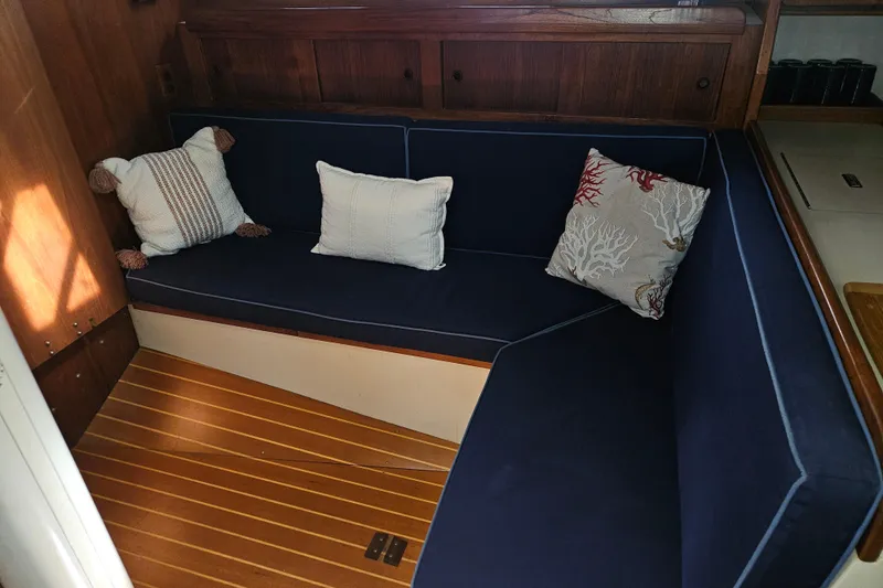 Slide: The Image of Cozy seating area in 1987 Morgan Classic 41 Center Cockpit with navy cushions and decorative pillows. - 21
