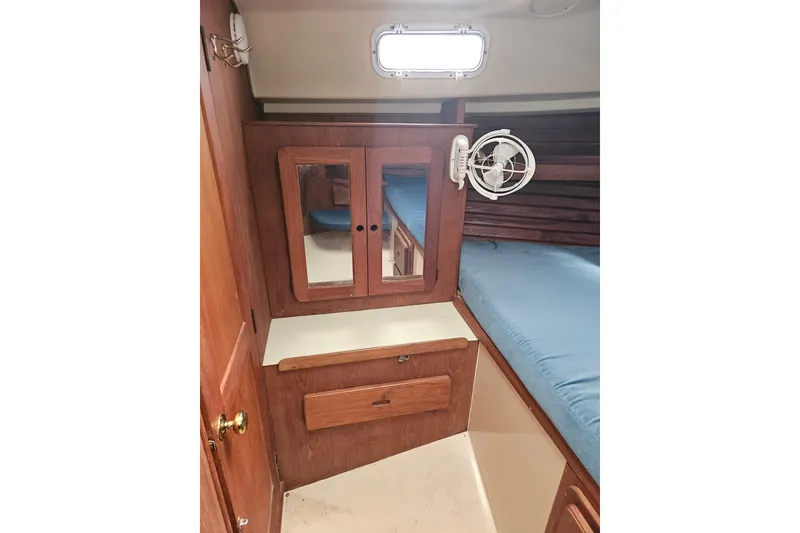Slide: The Image of Interior of 1987 Morgan Classic 41 Center Cockpit with wooden cabinetry and blue bedding. - 33