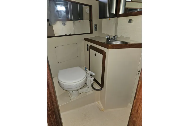 Slide: The Image of 1987 Morgan Classic 41 Center Cockpit bathroom with toilet, sink, and mirror. - 42