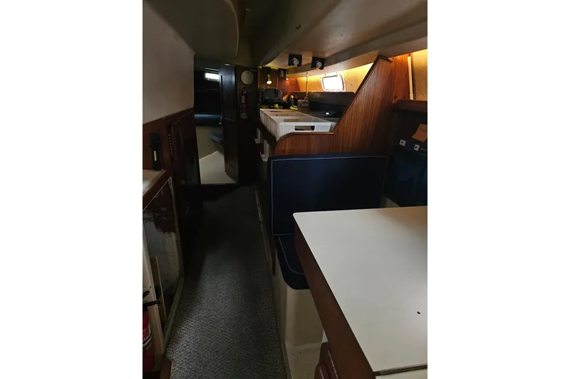 Slide: The Image of Interior of 1987 Morgan Classic 41 Center Cockpit yacht, featuring cozy wooden cabinetry and seating. - 44