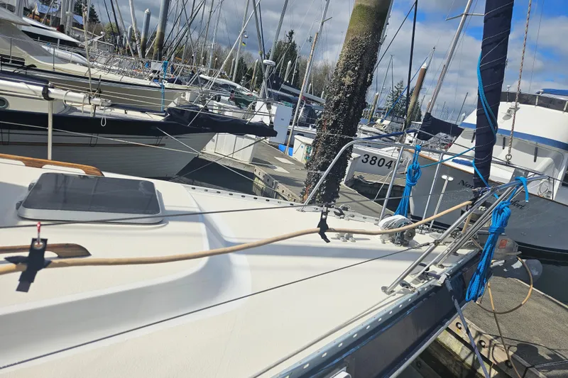 Slide: The Image of 1987 Morgan Classic 41 Center Cockpit sailboat docked in a marina, surrounded by other boats. - 6