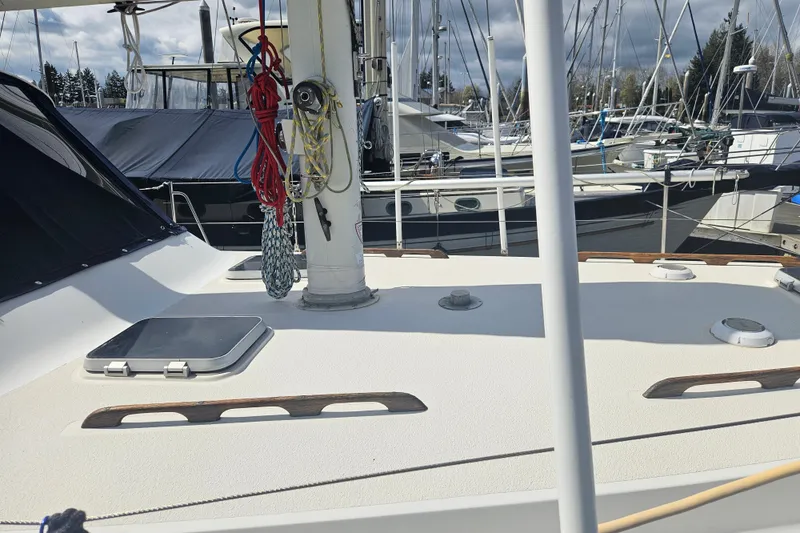 Slide: The Image of 1987 Morgan Classic 41 Center Cockpit sailboat deck with ropes and hatches in marina. - 7