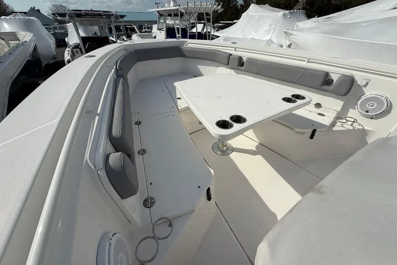 Slide: The Image of 2017 Everglades 355 Center Console boat interior with seating and table, showcasing cup holders. - 16