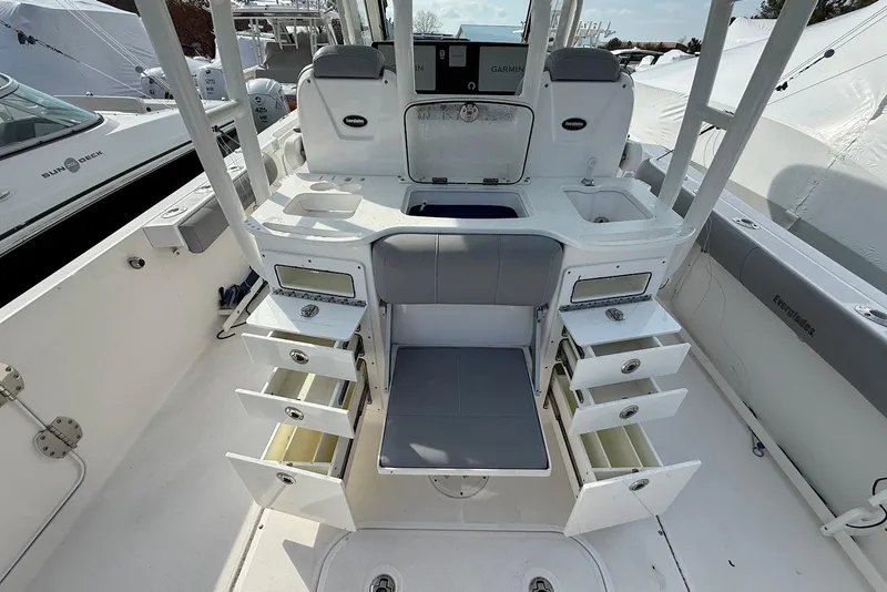 Slide: The Image of 2017 Everglades 355 Center Console boat interior with open storage compartments and seating. - 4