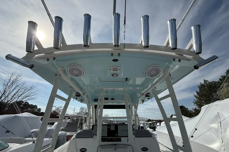 Slide: The Image of 2017 Everglades 355 Center Console boat with rod holders and electronics, under a cloudy sky. - 5