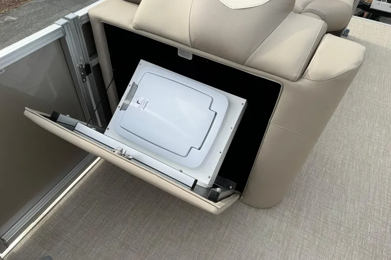 Slide: The Image of 2026 Avalon LSZ Quad Lounge boat seat with integrated storage compartment open. - 15