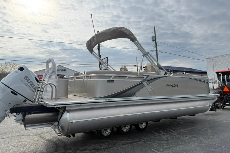 Slide: The Image of 2026 Avalon LSZ Quad Lounge pontoon boat with Suzuki engine, parked outdoors. - 4