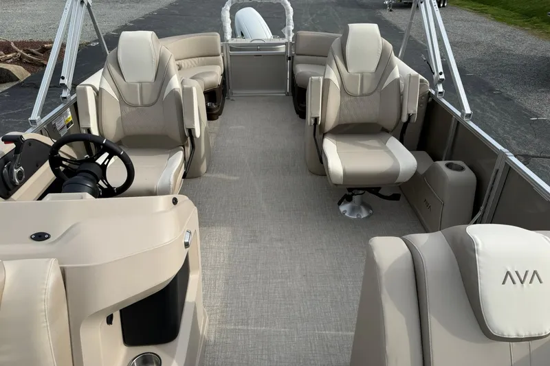 Slide: The Image of 2026 Avalon LSZ Quad Lounge 23' pontoon boat interior with beige seating and steering console. - 8