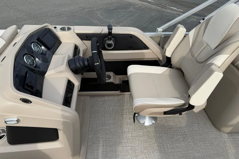 Slide: The Image of 2026 Avalon LSZ Quad Lounge boat interior with beige captain's chair and dashboard controls. - 9
