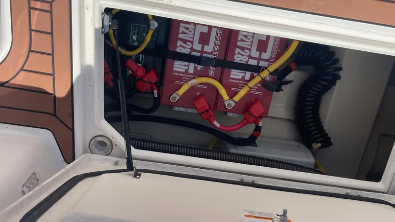 Slide: The Image of 2024 Ranger Tugs R-25 battery compartment with wiring and connections. - 10