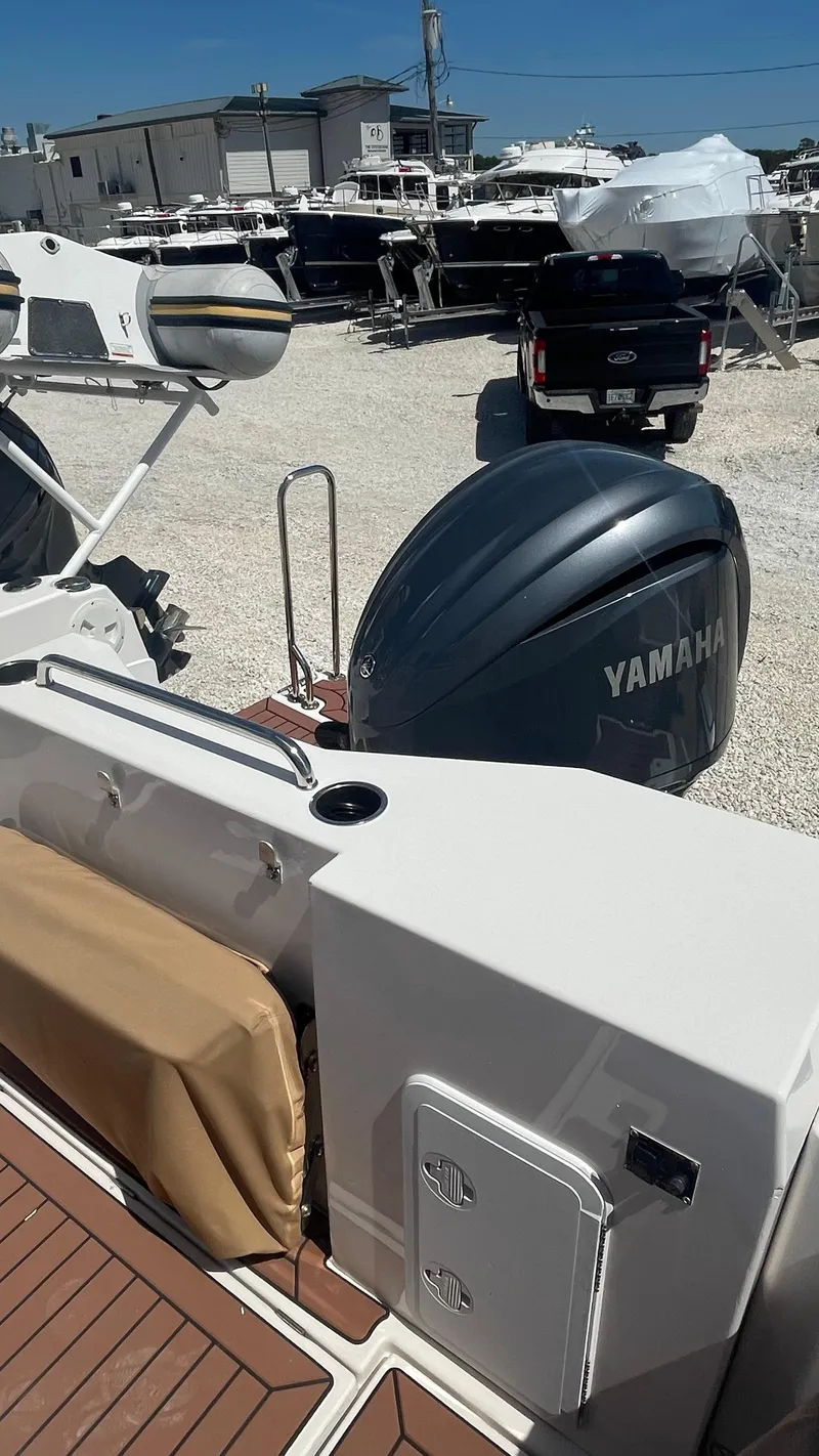 Slide: The Image of 2024 Ranger Tugs R-25 with Yamaha outboard engine in a boatyard setting. - 16