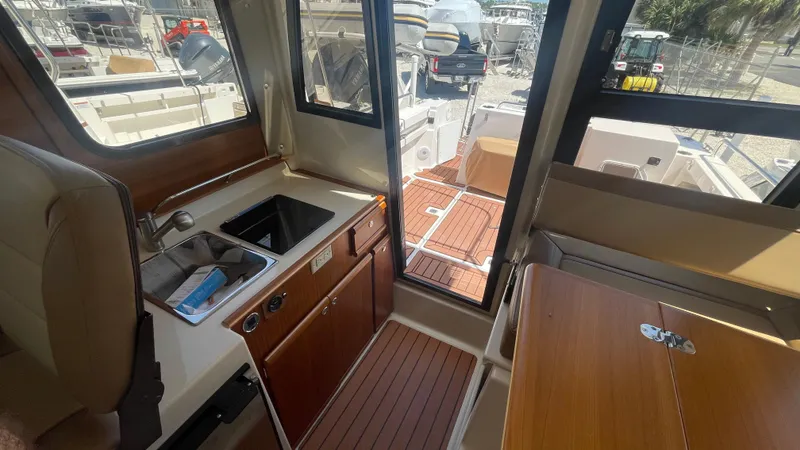 Slide: The Image of Interior view of 2024 Ranger Tugs R-25, featuring a compact kitchen area. - 19