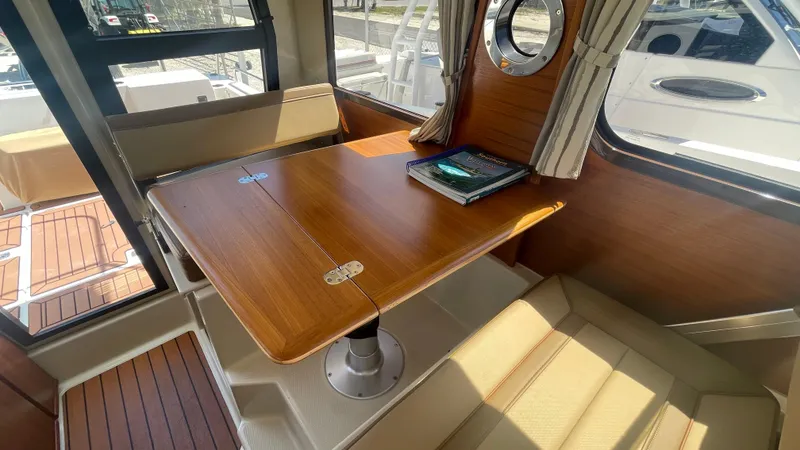 Slide: The Image of 2024 Ranger Tugs R-25 interior with wooden table and seating area. - 22