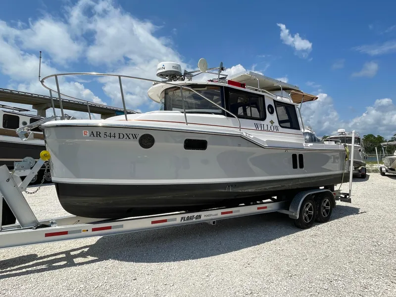 Slide: The Image of 2024 Ranger Tugs R-25 boat on trailer under clear blue sky. - 3