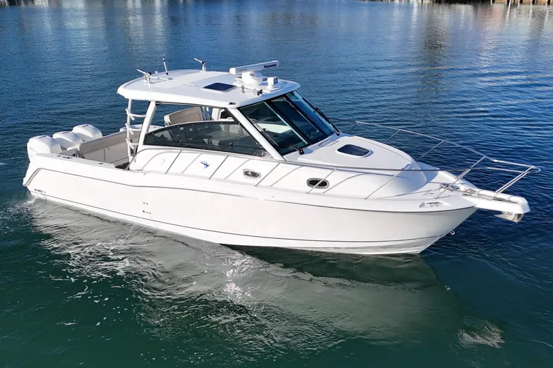 Slide: The Image of 2016 Boston Whaler 345 Conquest boat on calm water, showcasing sleek design. - 11