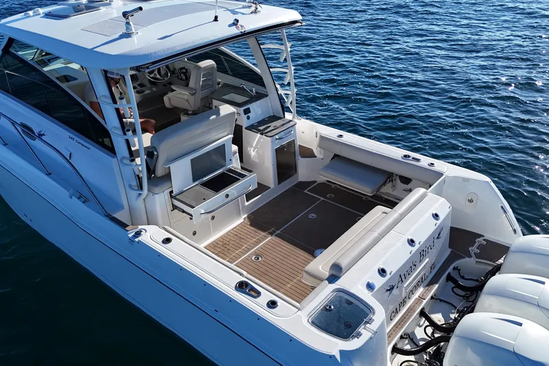 Slide: The Image of 2016 Boston Whaler 345 Conquest boat on water, featuring spacious deck and seating. - 12