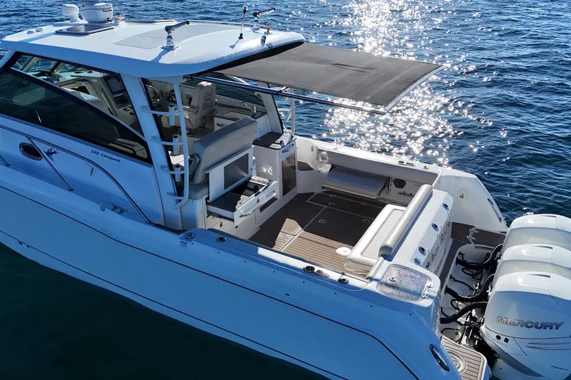Slide: The Image of 2016 Boston Whaler 345 Conquest boat on water, featuring spacious deck and triple Mercury engines. - 14