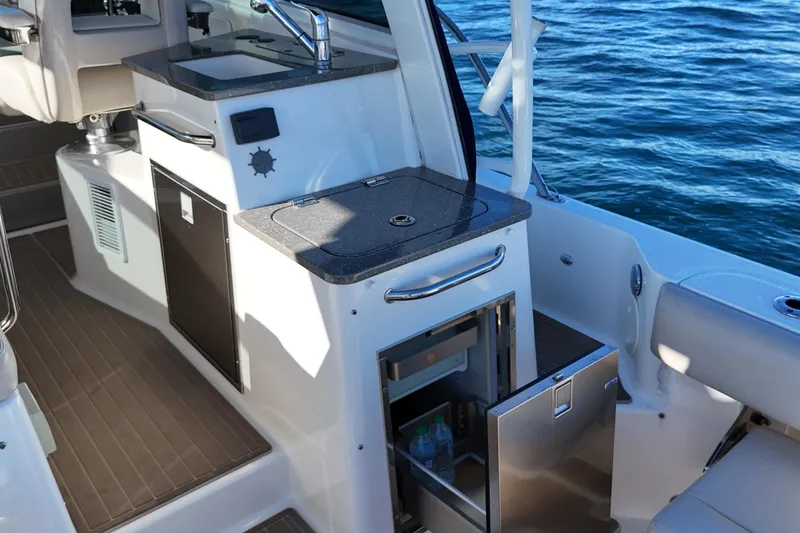 Slide: The Image of 2016 Boston Whaler 345 Conquest boat interior with kitchenette and ocean view. - 19