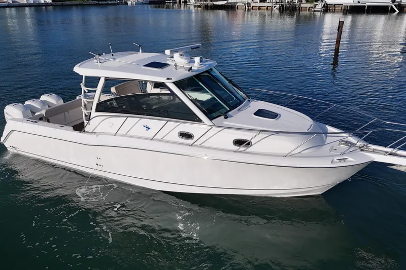 Slide: The Image of 2016 Boston Whaler 345 Conquest boat on calm water, showcasing sleek design and triple engines. - 20