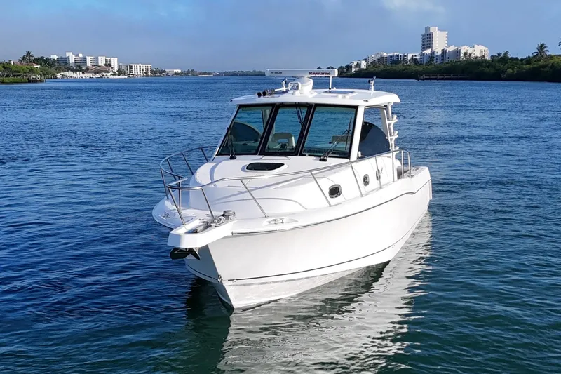 Slide: The Image of 2016 Boston Whaler 345 Conquest boat on calm water with cityscape background. - 4