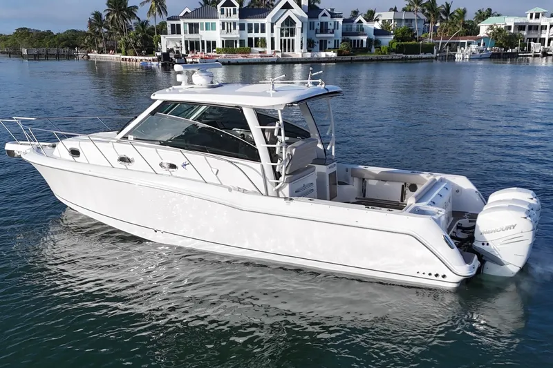 Slide: The Image of 2016 Boston Whaler 345 Conquest boat cruising near waterfront homes. - 5