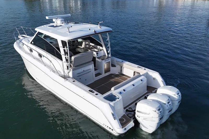 Slide: The Image of 2016 Boston Whaler 345 Conquest boat with triple Mercury engines on calm water. - 6