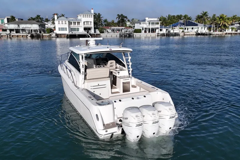 Slide: The Image of 2016 Boston Whaler 345 Conquest boat cruising near waterfront homes. - 7