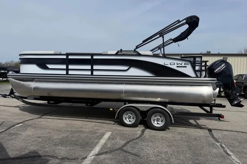 The Image of 2026 Lowe SF 232 Sport Fish pontoon boat on trailer, parked outdoors. - 0