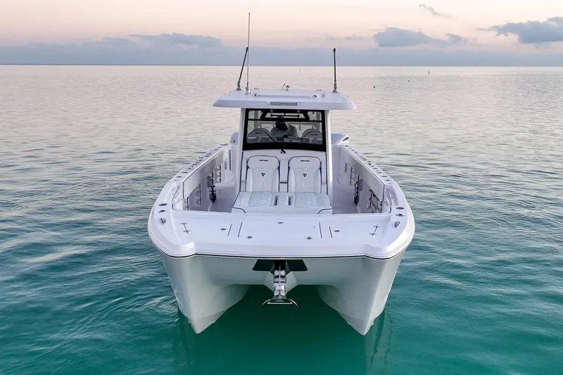 Slide: The Image of Manufacturer Provided Image: 2026 Twin Vee 400 GFX2 CC boat on calm water at sunset. - 2