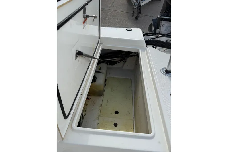 Slide: The Image of Open storage compartment on a 2014 Mako 21 LTS boat, showing interior space. - 12