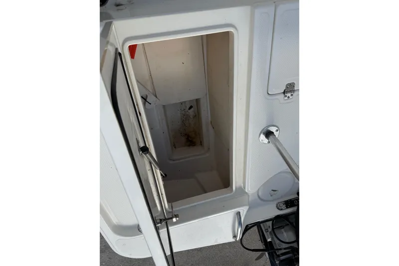 Slide: The Image of Open storage compartment on a 2014 Mako 21 LTS boat, showing interior space. - 13