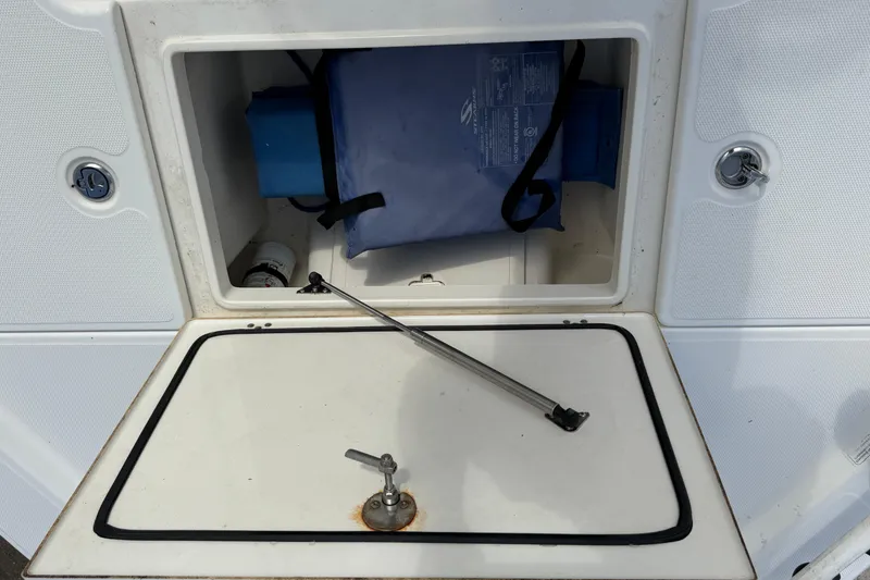 Slide: The Image of Open storage compartment on a 2014 Mako 21 LTS boat, showing interior contents. - 16