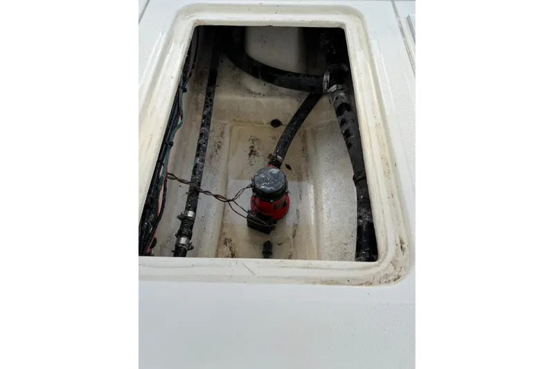 Slide: The Image of Open compartment of a 2014 Mako 21 LTS boat showing internal wiring and components. - 18