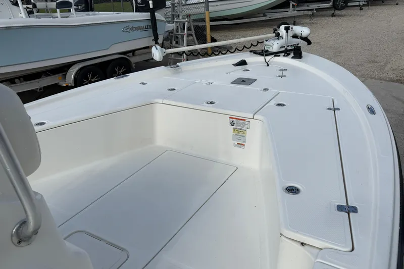 Slide: The Image of 2014 Mako 21 LTS boat deck with trolling motor and storage compartments. - 9