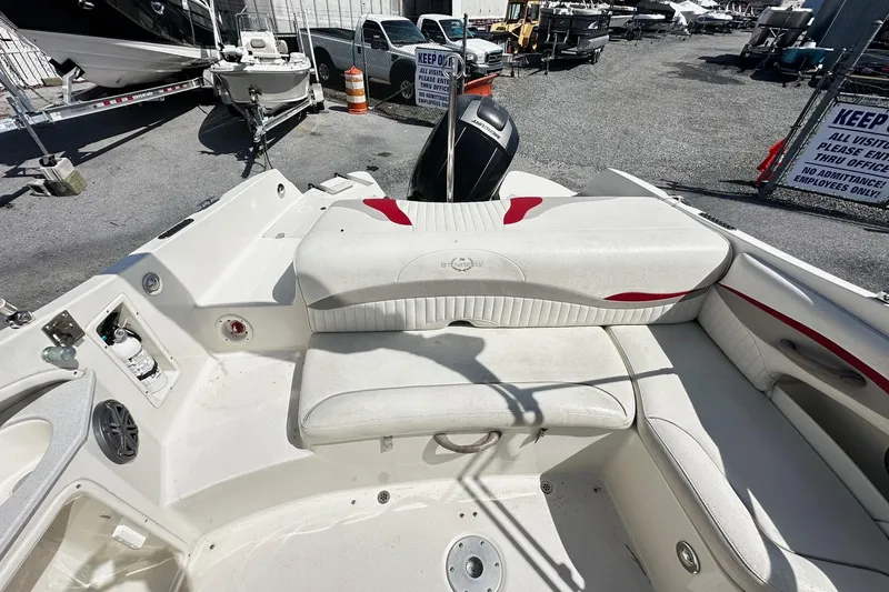 Slide: The Image of 2012 Stingray 234 LR boat interior with white seating and red accents, displayed outdoors. - 10