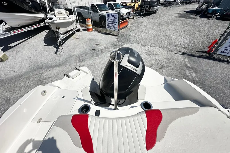 Slide: The Image of 2012 Stingray 234 LR boat with Mercury engine in a marina parking area. - 11