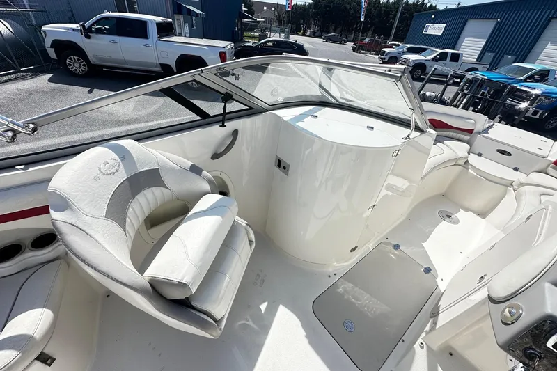 Slide: The Image of Interior of a 2012 Stingray 234 LR boat with white seating and dashboard. - 7