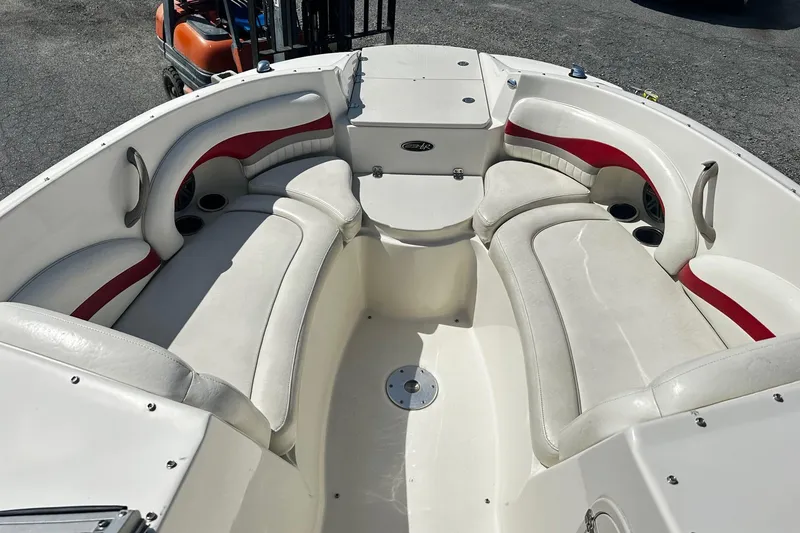 Slide: The Image of 2012 Stingray 234 LR boat interior with white and red seating, cup holders, and storage. - 8