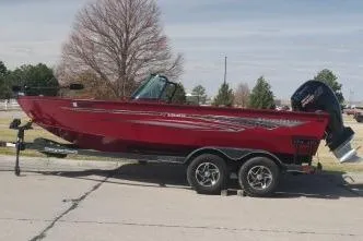 The Image of 2023 Ranger VS1882 WT boat in red on a trailer, parked outdoors. - 1