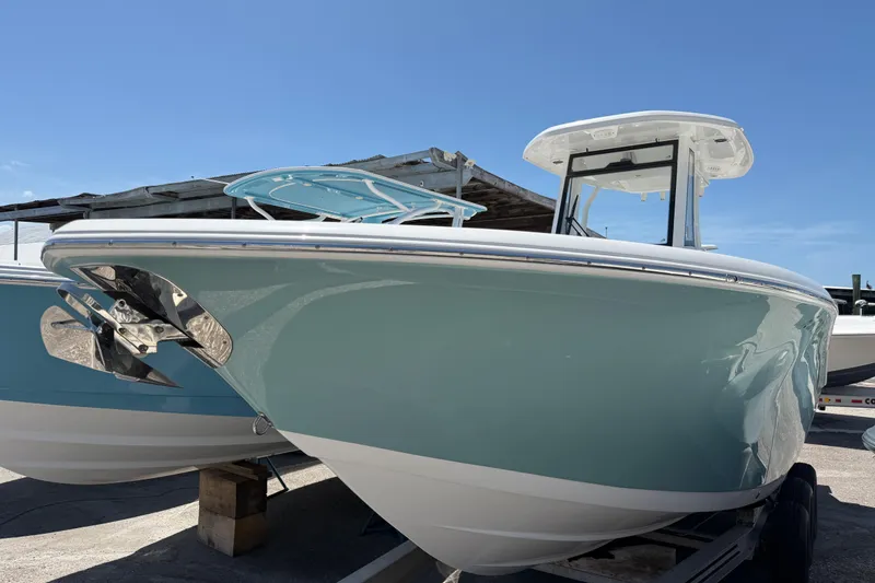 Slide: The Image of 2022 Tidewater 256 LXF boat with sleek design, displayed outdoors under clear blue sky. - 3