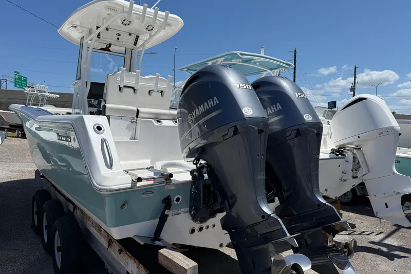 Slide: The Image of 2022 Tidewater 256 LXF boat with dual Yamaha 150 engines on a trailer. - 4