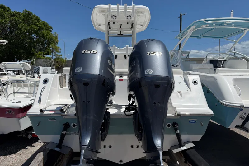 Slide: The Image of 2022 Tidewater 256 LXF boat with dual Yamaha 150 engines, docked outdoors. - 5