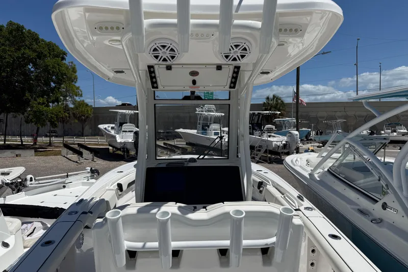 Slide: The Image of 2022 Tidewater 256 LXF boat with T-top and rod holders, docked under clear skies. - 6
