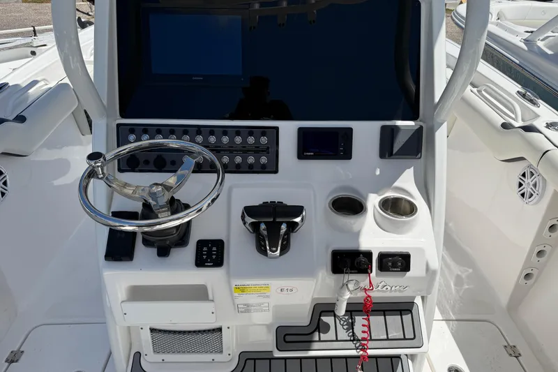 Slide: The Image of Control panel of a 2022 Tidewater 256 LXF boat with steering wheel and controls. - 7