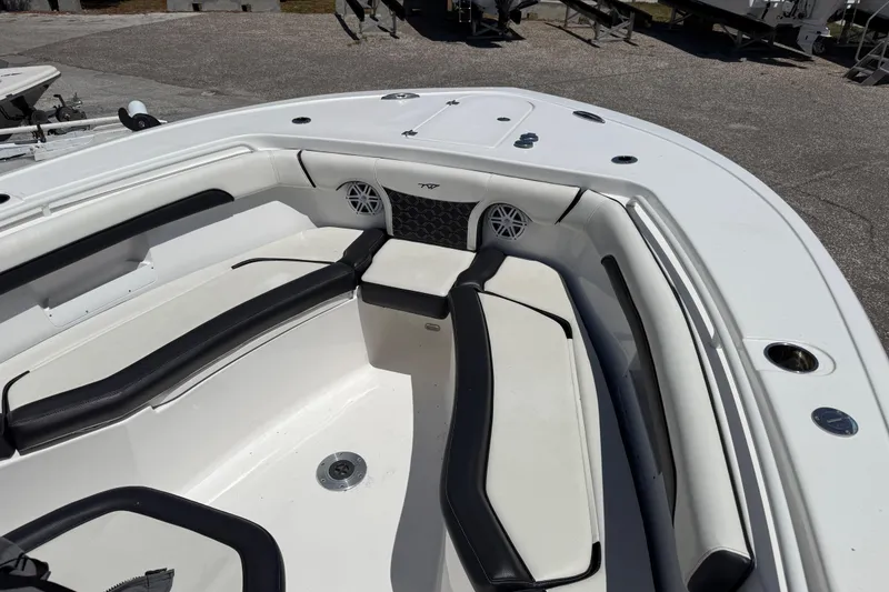 Slide: The Image of 2022 Tidewater 256 LXF boat interior with cushioned seating and speakers. - 9