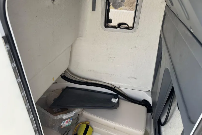 Slide: The Image of Interior cabin of 2005 Campion Explorer 582 Center Console boat, featuring storage and seating. - 9
