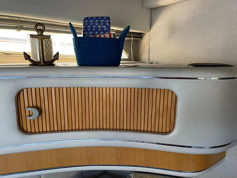 Slide: The Image of 1989 Sea Ray 420 interior with wooden cabinet, nautical decor, and anchor-themed accessories. - 21