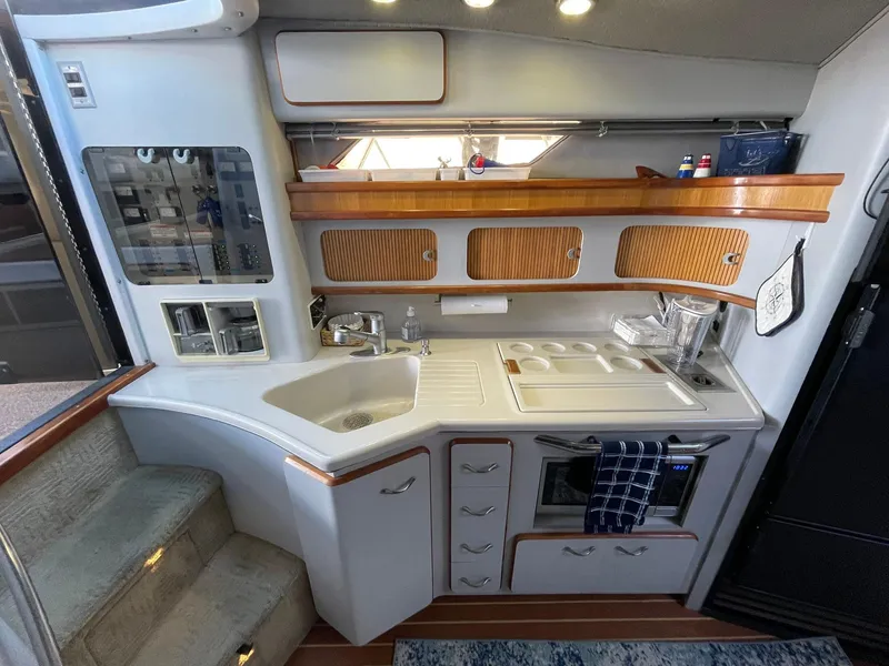 Slide: The Image of 1989 Sea Ray 420 yacht kitchen with sink, stove, and storage cabinets. - 27