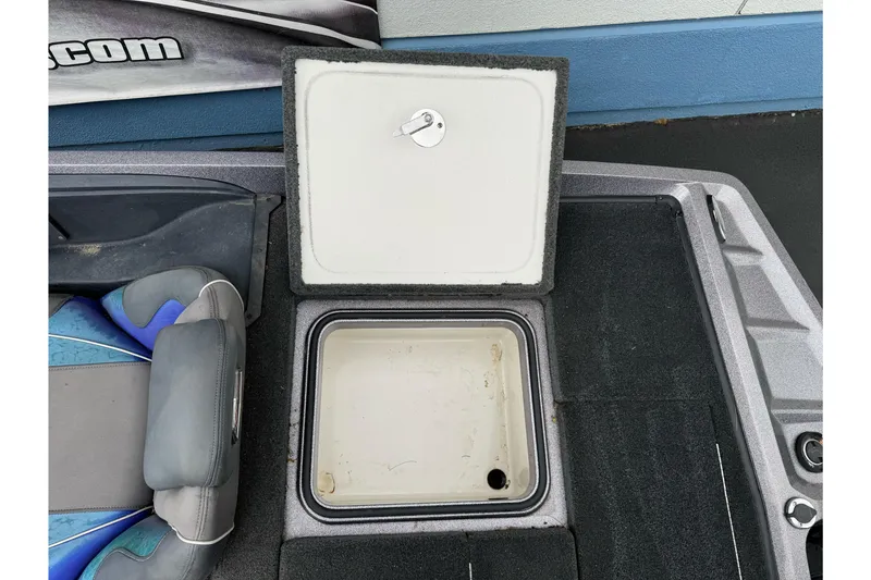 Slide: The Image of Open storage compartment on 2017 Ranger Z185 boat, featuring gray and blue seating. - 25